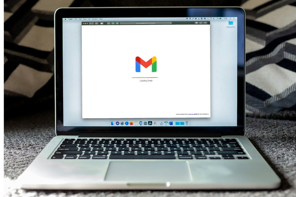 Laptop computer showing a screen opened with a white background and the gmail logo to indicate email marketing