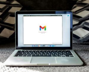 Laptop computer showing a screen opened with a white background and the gmail logo to indicate email marketing