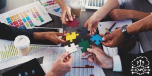 hands holding puzzle pieces together over a meeting room table